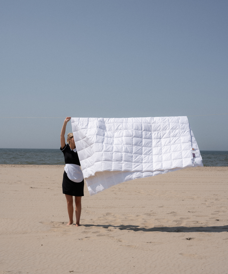 Zomer dekbed hotelkwaliteit op waslijn met hotelschoonmaakster
