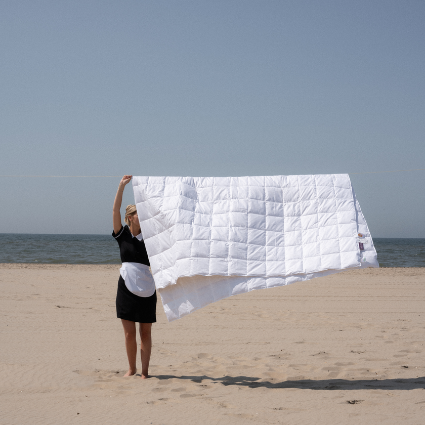 Zomer dekbed hotelkwaliteit op waslijn met hotelschoonmaakster