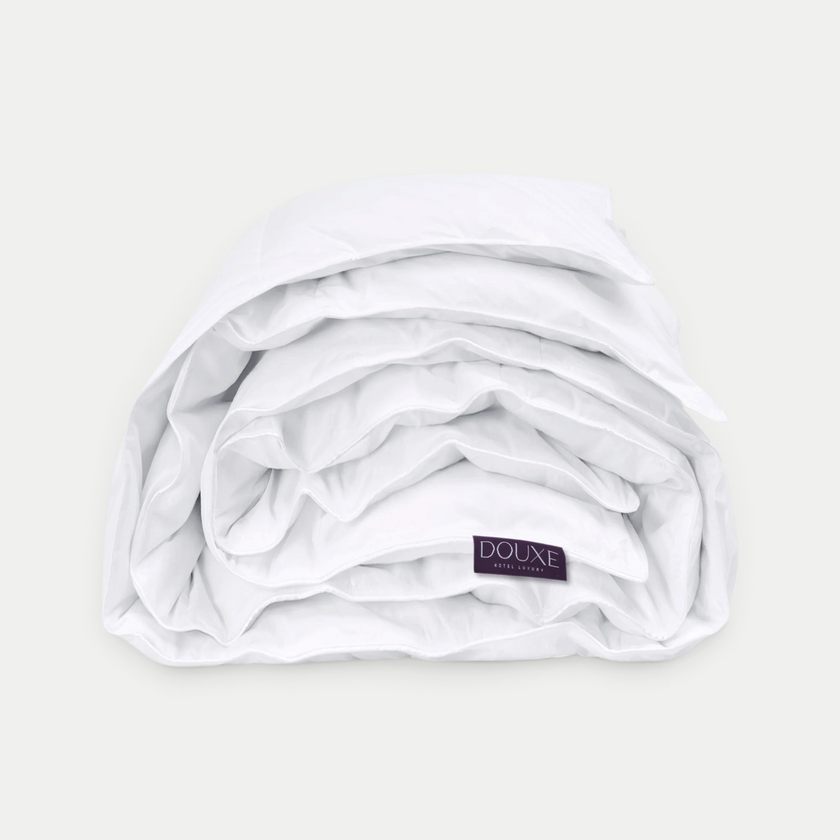 Luxe wit DOUXE dekbed opgevouwen met merklabel zichtbaar