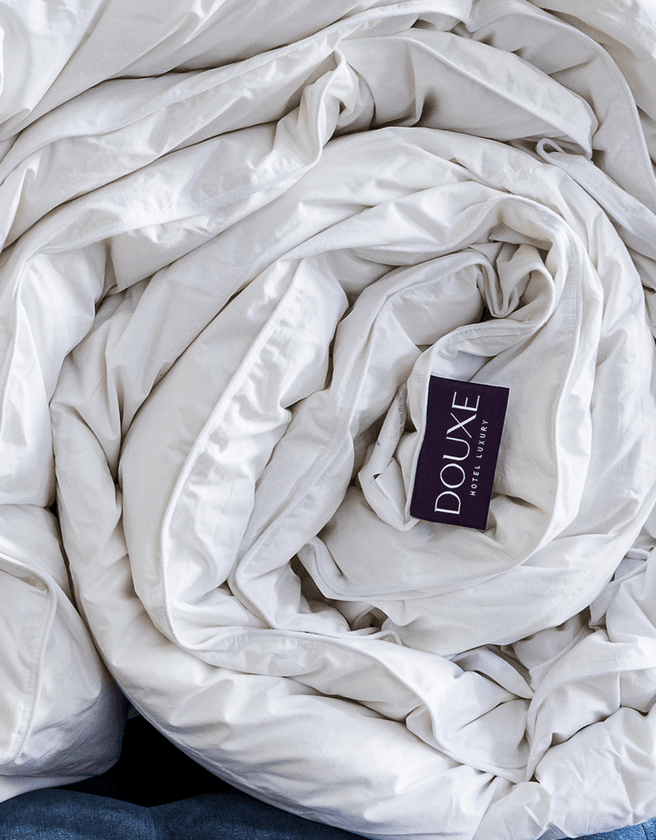 hotel dekbed met DOUXE logo opgerold van 100% dons voor 4 seizoenen