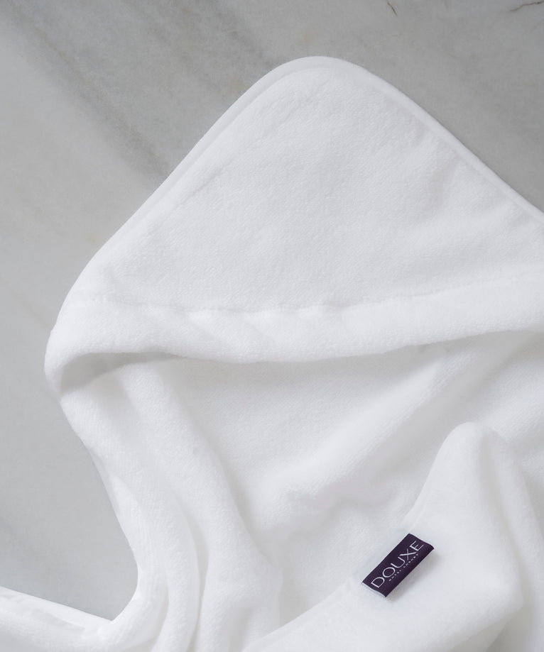 badcape baby in wit, detail shot van capuchon en DOUXE logo met marmeren achtergrond